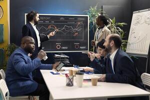 Corporate team following international sales process and client feedback, using interactive board to present resources and profit. Employees working on brand differentiation strategies for growth. photo