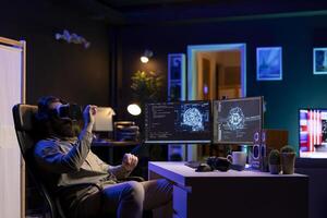 Developer using VR headset technology to update artificial intelligence machine learning algorithm, writing binary code scripts. IT expert programming using virtual reality tech to upgrade AI brain photo