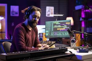 Portrait of artist producer playing midi controller notes and adding them on new song, using daw software interface to mix and master tunes. Skilled musician creating music with piano keys. photo