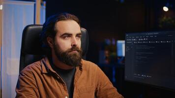 Developer overthinking solutions while doing programming during remote job shift in home office while drinking coffee. IT admin enjoying hot beverage working on PC early in the morning, camera B photo