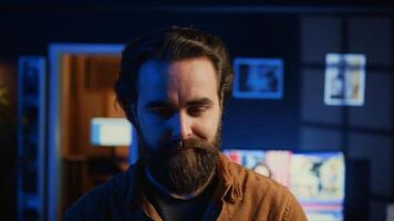 Portrait of happy man doing IT support job from apartment, standing in personal office with laptop in hand, coding. Joyful developer writing lines of code on notebook, camera B close up shot photo