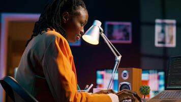 African american system engineer using AI system to write computer program code, html terminal window. Woman works with deep learning algorithms, artificial intelligence neural networks. Camera A. photo