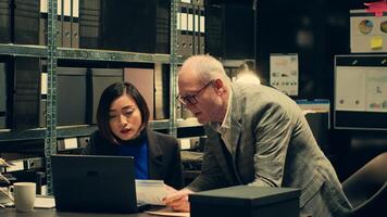 Private investigation team searching for details in case files, analyzing financial records to trace money laundering schemes. Police officers look for clues to catch criminal. Camera A. photo