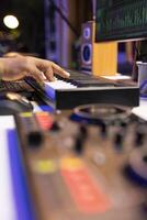 Artist composer playing a track on midi controller in home studio, adding piano notes on an old audio recording. Sound engineer producing modern tracks on stereo console. Close up. photo