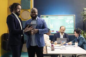 Team of company analysts reviews feedback on sales and orders to work on future improvements, developing marketing and PR strategies in meeting room. Startup enterprise managers. photo