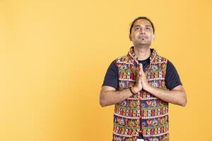 Man putting hands together in begging gesture, looking upwards to deity to make wish. Faithful person asking for help from god, praying to higher power, isolated over studio backdrop photo