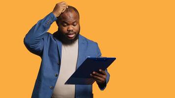 Accountant doing profit analysis for company, feeling perplexed by confusing data, studio background. Worker doing financial budgeting, scratching head, puzzled by financial figures, camera A photo