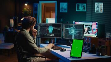 Focus on isolated screen tablet next to programmer updating artificial intelligence, making it become sentient. IT specialist programming self aware AI with chroma key device, camera B photo