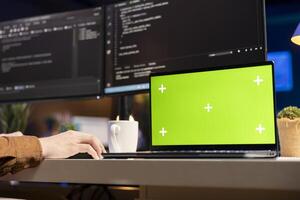 Developer working on isolated screen laptop, futureproofing company network from downtimes and unexpected system failures. Admin using chroma key notebook, increasing data security, close up photo