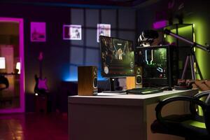 Empty apartment living room with neon lights and gaming computer with first person shooter game left open on monitor. Singleplayer videogame on desktop pc display on desk late at night photo