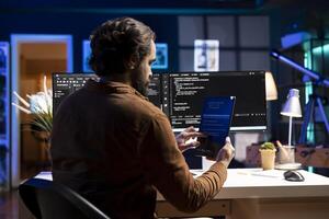 Programmer using tablet to fix vulnerabilities in software enabling attackers to compromise systems. Man taking care of security exposures in operating system, writing code on device photo