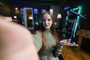 POV of joyous gen Z girl recording introductory with smartphone on selfie stick, inviting viewers to subscribe to channel. Influencer uses selfie camera to film herself connecting with fanbase photo