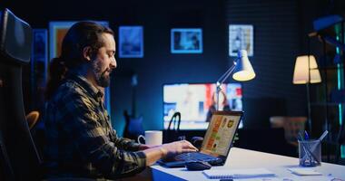 Self employed man working in personal office, checking statistical data financial graphs on laptop screen. Remote employee in living room comparing business graphic economic figures, camera B photo