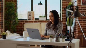 Self employed woman sitting at computer desk, typing on laptop keyboard in personal office. Freelancing businesswoman inputting data on notebook, doing her job before deadline photo