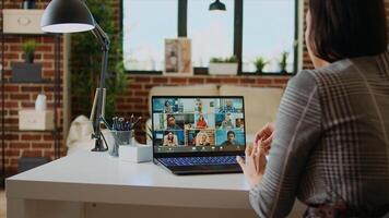 Remote employee in cozy apartment talking with coworkers during teleconference meeting. Teleworker at home participating in internet videocall with colleagues, camera A zoom in close up shot photo