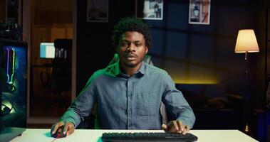 African american player shouting after failing to win videogame while playing on gaming PC. Upset gamer at computer desktop in apartment feeling like smashing desk, raging after game over photo