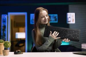 Content creator typing on mechanical keyboard while doing review in personal studio to see if price is justified. Technology guru showcasing computer peripheral features to fans photo