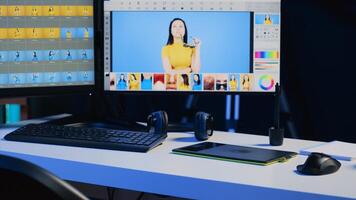 Photo editing software on PC display and graphic tablet on desk in empty multimedia creative studio. Industry standard retouching program on computer screen and touchscreen device, panning shot