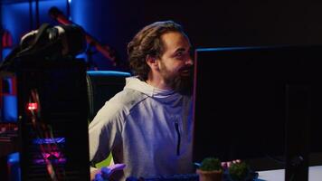 Streamer arriving in studio, ready to start streaming for online viewers, talking with them. Pro gamer broadcasting from dark living room, greeting fans watching him on internet channel photo