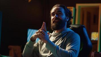 Streamer in neon illuminated apartment chatting with audience, providing them with useful gaming insights. Pro gamer doing livestream, presenting viewers his favorite esports strategies photo