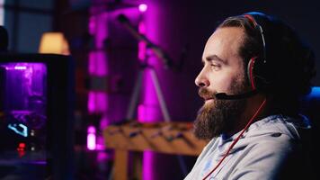 Man discussing with friends online while playing singleplayer videogame with spaceship shooting at asteroids, panning shot. Close up of gamer chatting with teammates in SF game using headphones mic photo