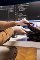 Programmer packing backpack at end of day after securing company servers from virus attacks, close up. IT remote employee finishing job shift, leaving office after building firewalls protecting data photo