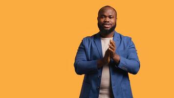 Approving joyful african american man happily clapping hands, ecstatic about accomplishments. Excited BIPOC person cheering, applauding, isolated over studio background, camera B photo