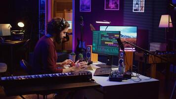 Music engineer operates recording equipment in home studio, working with mixing consoles and digital audio workstations to create sound effects on soundtracks. Production techniques. Camera B. photo