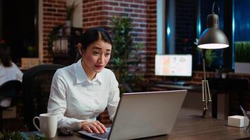 Smiling businesswoman saluting colleagues during company meeting on internet videocall in office. Employee speaking in remote videoconference telework call, brainstorming project ideas photo