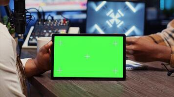 Man invited to podcast watching internet clips on isolated screen tablet with host in apartment studio. Guest reacting to videos on chroma key device during online comedy show photo