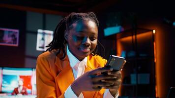 College student doing her homework at laptop and texting on phone, enjoying school break to check social media apps. Girl researching for assignments and using smartphone. Camera B. photo