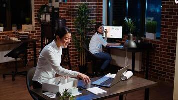 Woman dancing and singing while packing desk belongings, excited to change offices after job promotion. Joyful employee being advanced in company hierarchy, celebrating, saluting colleague, camera A photo