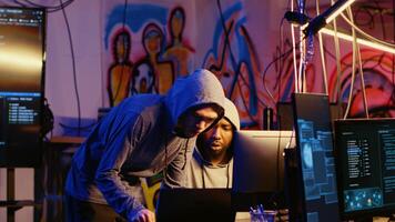 Rogue programmers in secret hideout discussing ways to best hide their online activity after stealing data from victims through hacking, trying to avoid being detected by cybercrime law enforcement photo