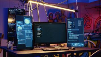 Close up shot of software interface on computer screens showing developer code running in empty criminals den with graffiti sprayed on walls. Hacking malware programming in underground base photo