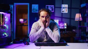 Gamer unhappy with teammates performance while playing esports tournament, struggling to win. Player feeling stressed while competing with friends in multiplayer videogame, frustrated by loss photo