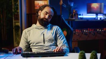 Lethargic man addicted to gaming feeling extremely tired and disconnected from reality after engaging in online multiplayer games all day. Drowsy man exhausted from playing too many videogames photo