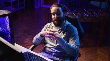 Professional gamer in studio teaching viewers strategies to beat opponents during livestream. Content creator streaming live from RGB lit home, filming videogames guides for internet audience photo