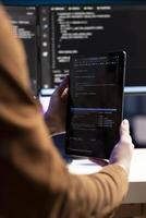 Teleworking programmer designing and developing software applications using tablet. IT administrator implementing and maintaining company systems using portable device, close up photo
