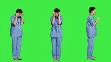 Stressed furious nurse screaming at someone against greenscreen backdrop, showing rage and anger in studio. Aggressive upset medical assistant shouting and being dissatisfied. Camera A. photo