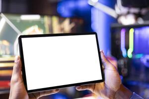 Gamer watching tutorial on isolated screen tablet showing tips for videogame he is currently playing, close up. Player looking online for game guide on mockup portable device, stuck on mission photo