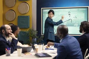 Chief financial officer presenting capital funds and revenue data on annual reports in a conference room, reviewing profit increase and budget allocation for a project. Informative meeting. photo