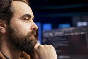 Freelancing programmer working from home, designing and developing software applications. IT specialist looking at desktop PC monitor, implementing and maintaining company systems, close up photo