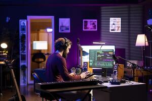 Music producer working on editing soundtracks and audio recordings with daw software interface on pc, adding sound effects and creating new tracks. Professional songwriter works in home studio. photo