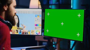 Photo editor using green screen monitor to look at editorial pictures taken with professional camera for fashion magazine in photography studio. Freelancer browsing images on mockup PC in media agency