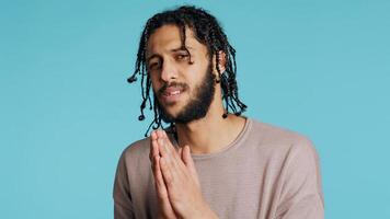 Desperate guy asking for forgiveness, putting hands together in imploring gesturing, showing regret emotion. Upset man saying sorry, begging for apology, feeling guilty, studio background, camera B photo