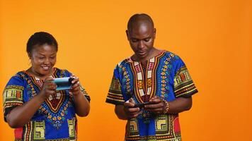 Cheerful woman winning videogames competition in studio, feeling happy about victory while she plays online with her husband. Young man feeling frustrated about losing to his girlfriend. photo
