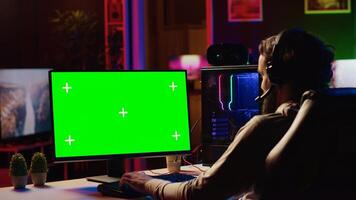 Player having fun by using isolated screen computer monitor to play singleplayer videogame. Professional gamer using chroma key PC desktop to complete levels in game, talking with friends photo