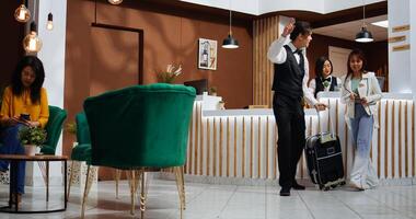 After check in process, receptionist handing over passport and key for room access at five star hotel. Professional employee providing great services for guest at front desk, confirming id papers. photo