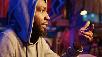Close up shot of hacker talking to colleague, brainstorming ways to find exploits for system vulnerabilities and use them to sell the fix to system owner. African american wicked programmer hacking photo