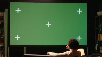 Man using streaming services on ultrawide chroma key TV to binge watch series from the comfort of his apartment. Cord cutter enjoying shows on television set during leisure time on couch photo